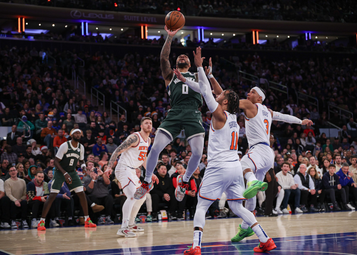 Damian Lillard jumps up for a layup as Knicks players try to defend him